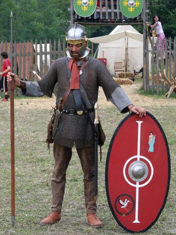 A picture of a Roman re-enactor in chain armor with an oval shield.